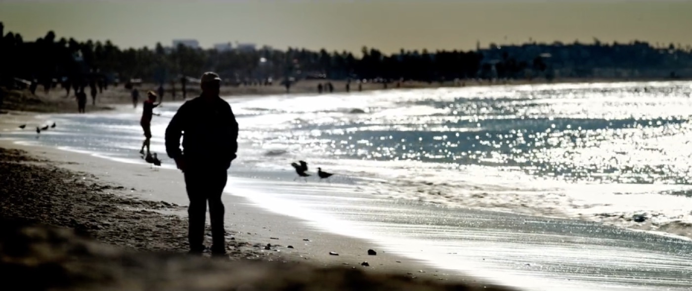 A silhouetted figure walking on the beach