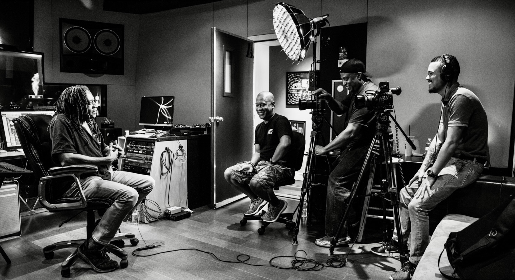 Production crew filming an interview in a recording studio